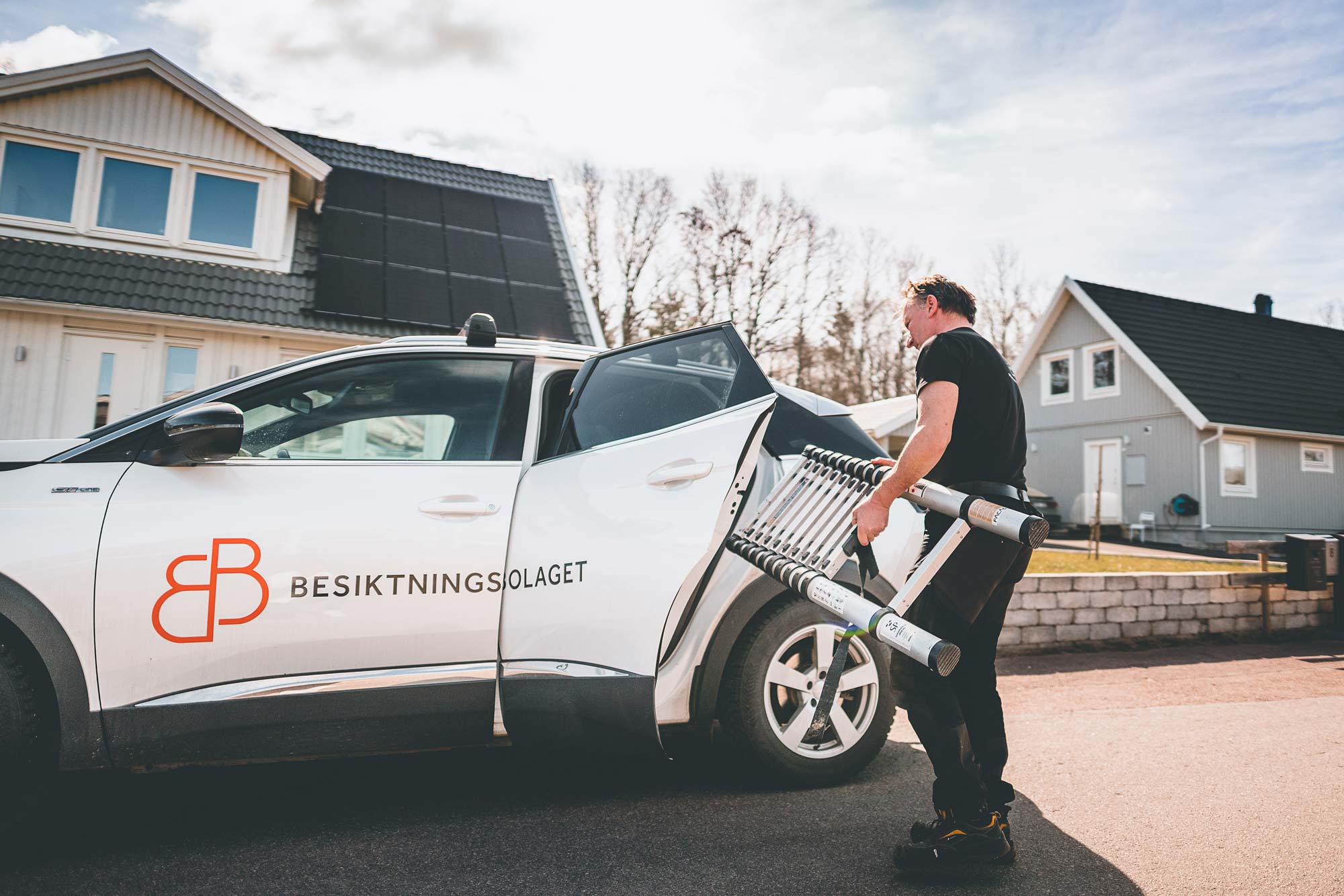 Beskitningsman som tar ut en stege ur sin bil
